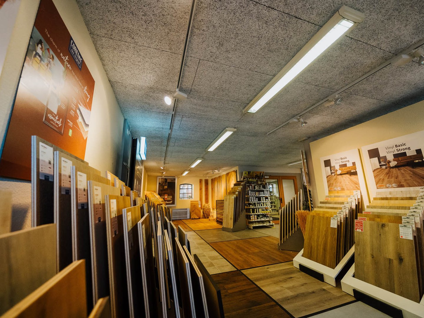 "Ausstellungsgang mit großflächigen Parkett- und Vinylbodenmustern auf Wand und Boden bei der Holzhandlung Ströbele